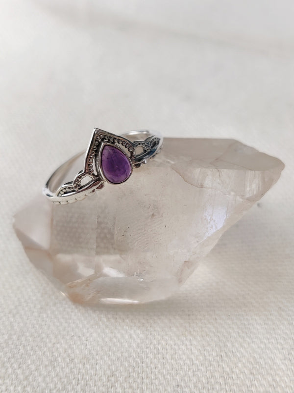 This is a sterling silver ring with a tear drop design and amethyst crystal gemstone light purple in colour, sitting on top of a clear quartz crystal, both available at our third eye crystal store in Auckland New Zealand