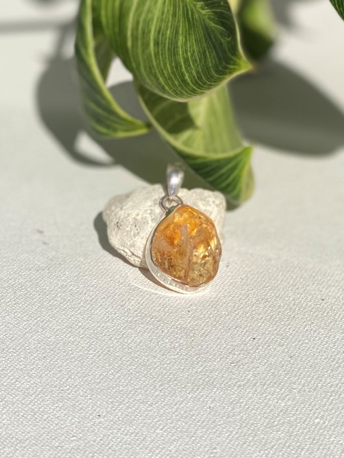 Sterling Silver PENDANT with a large rough citrine stone on a light fabric background