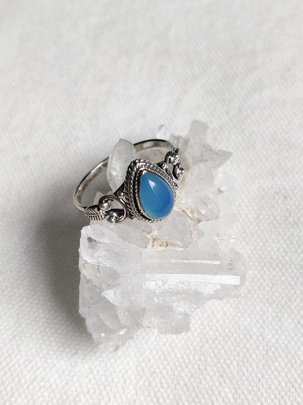 This is a sterling silver ring with a tear drop design and chalcedony crystal gemstone light blue in colour, sitting on top of a clear quartz crystal, both available at our third eye crystal store in Auckland New Zealand